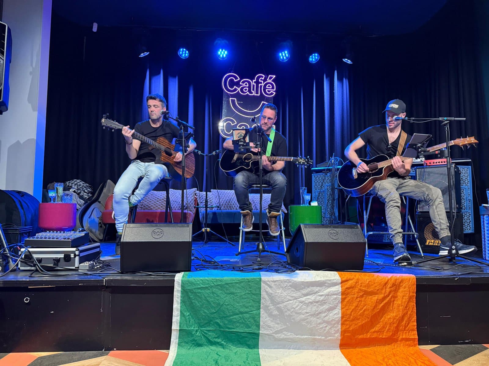 The Lonesome Lads live in het café, met de Ierse vlag over het podium