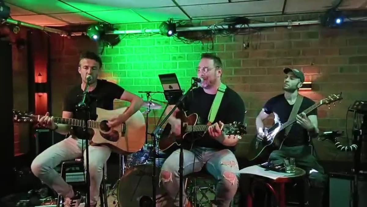 The Lonesome Lads op een podium met groen licht